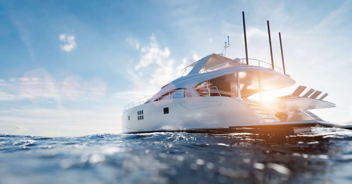 A large white yacht charter with black panels on the side is sitting still in the middle of the ocean.